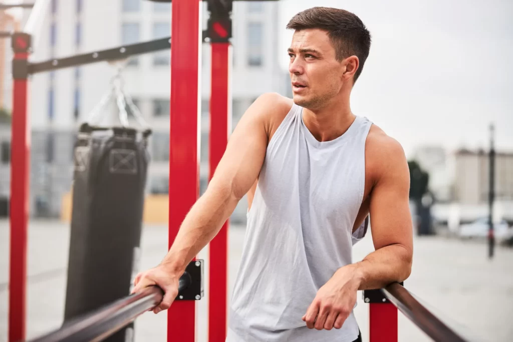 man pauses from exercise outdoor gym in city utc